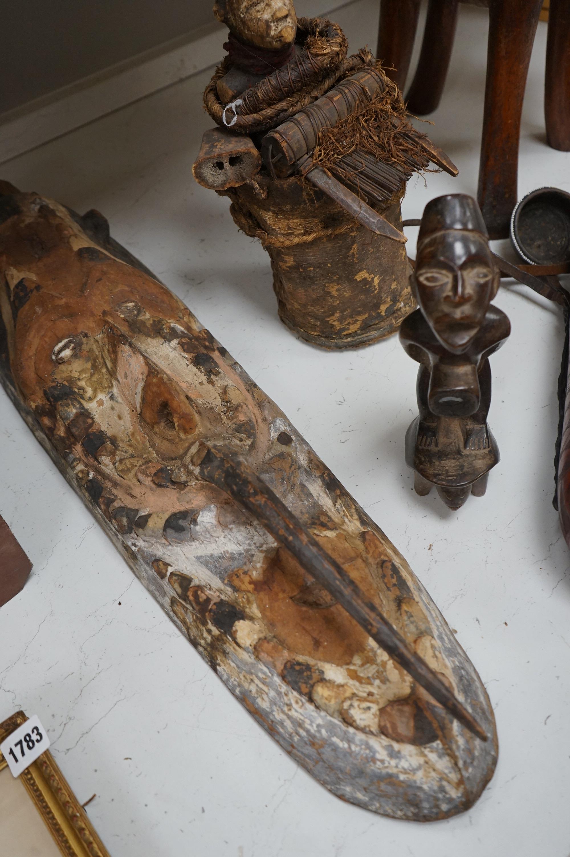 A group of African tribal artefacts, including a stool, a large painted carved mask, a carved gourd container and three carved figures, mask 76cm high. Condition- fair to good